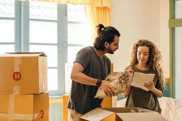 happy couple packing boxes with fragile items
