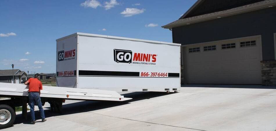 a go mini's moving container is being offloaded into a driveway
