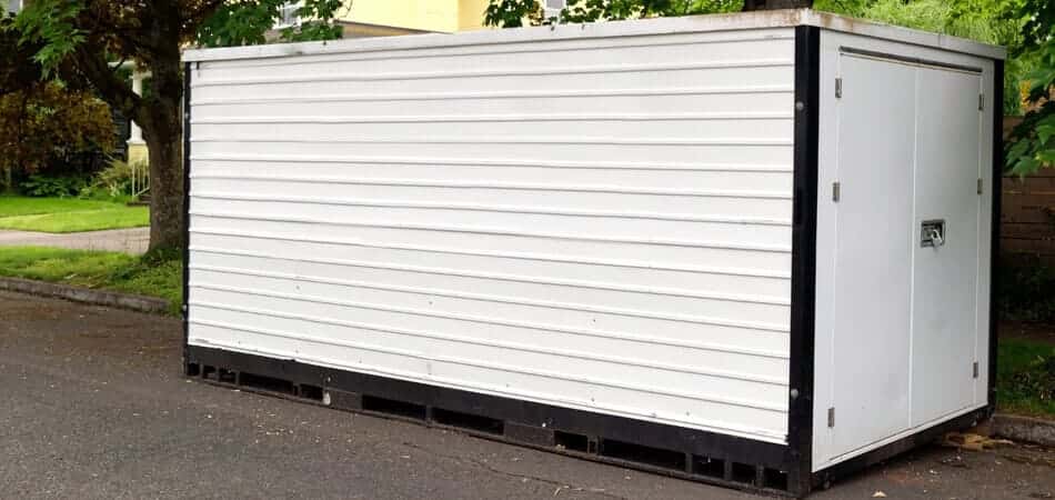 A white moving container sits on a residential street