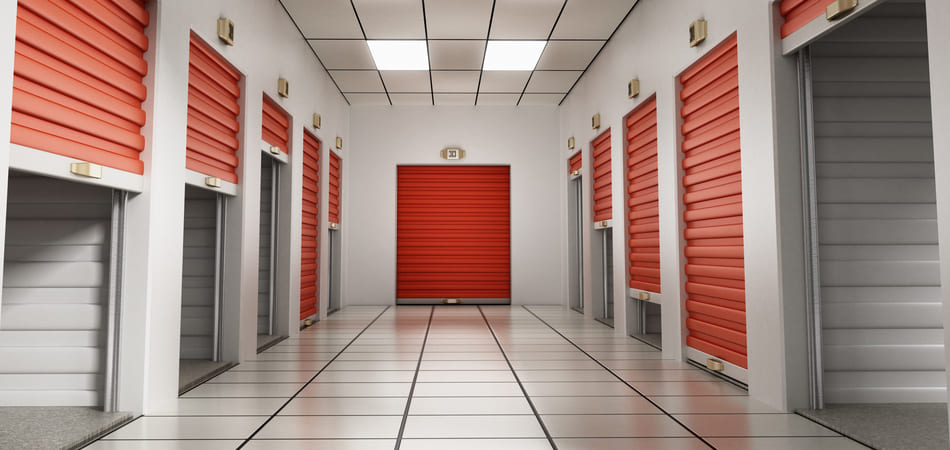 a self-storage facility hallway with orange doors on both sides and some are open