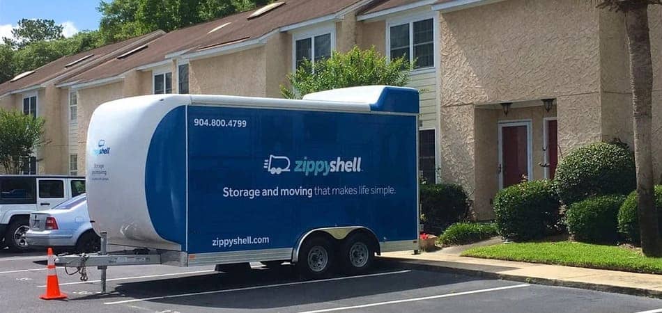 a Zippy Shell storage container is parked in a driveway