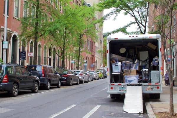 a U-Haul truck is loaded with household goods and parked on a city street