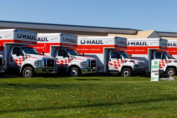 several U-Haul trucks sit at a U-Haul facility ready to be rented