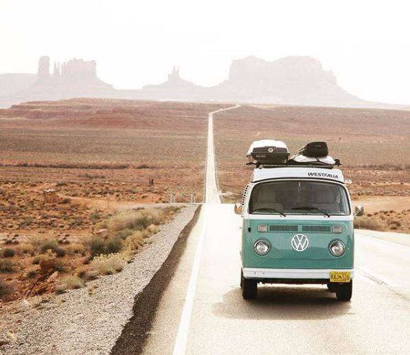 an old VW van on an empty desert road