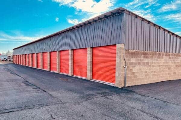 Storage units with orange doors at an outside self-storage facility