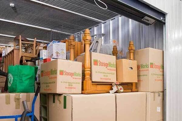 A self storage unit is fully packed with boxes and furniture