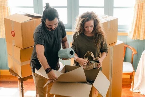 man and woman pack carboard moving boxes