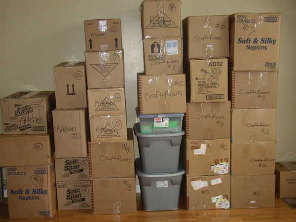 Moving boxes and plastic tubs are stacked neatly